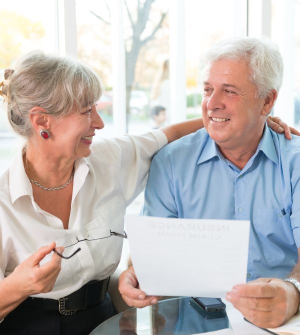 Happy senior couple holding paperwork